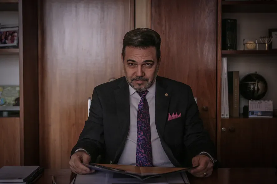 Pastor e deputado Marco Feliciano em entrevista sobre influência evangélica na política, com fundo do Congresso Nacional.