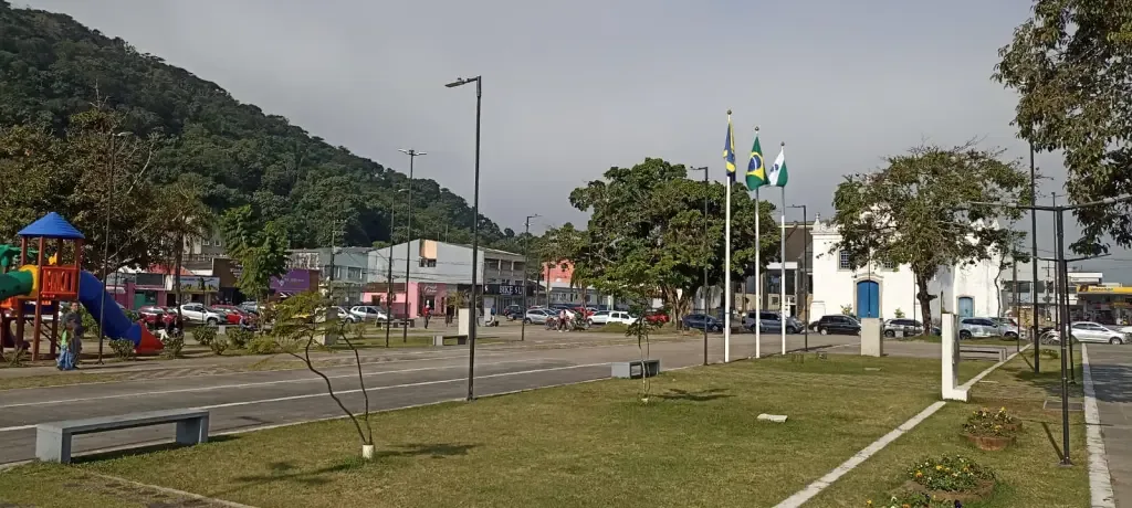 Palco gospel montado na praça central de Guaratuba com músicos tocando e público presente, ao fundo barracas e fiéis durante 