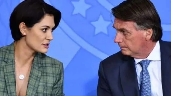 Michelle Bolsonaro no púlpito de igreja evangélica, com mãos postas e Bíblia, durante culto onde declarou 'cônjuge acima de t