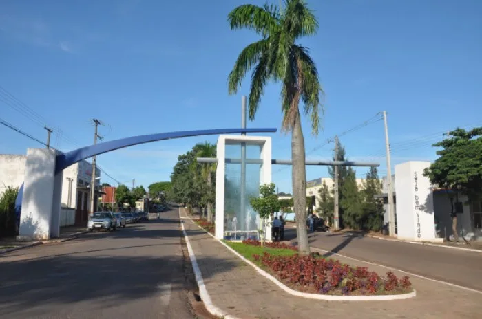 Homem sendo resgatado por bombeiros do telhado de igreja com colchão inflável na calçada e fiéis observando.