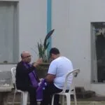 Missionário Pitter Di Laura fala ao microfone em coletiva de imprensa na Canção Nova, com banner do PHN 2026 ao fundo.