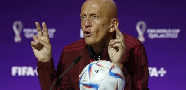Pierluigi Collina em coletiva de imprensa com logo da Fifa ao fundo, defendendo o uso do VAR na Copa.