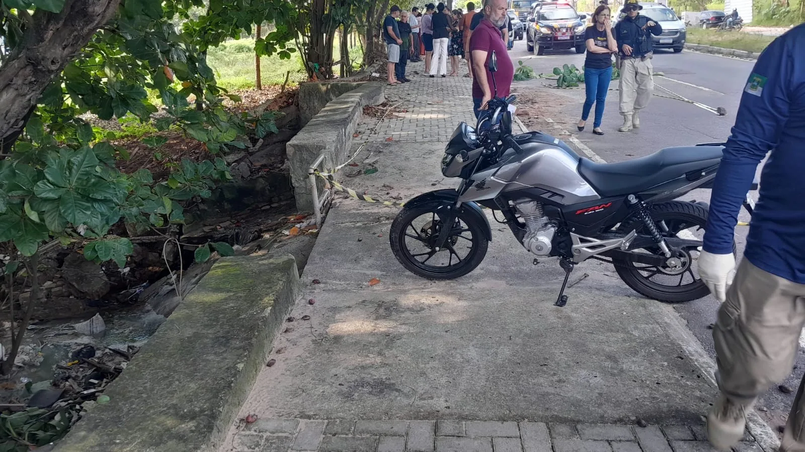 Motocicleta destruída e ônibus parado em acidente na BR-226, em Natal, com equipe de resgate e PRF no local.