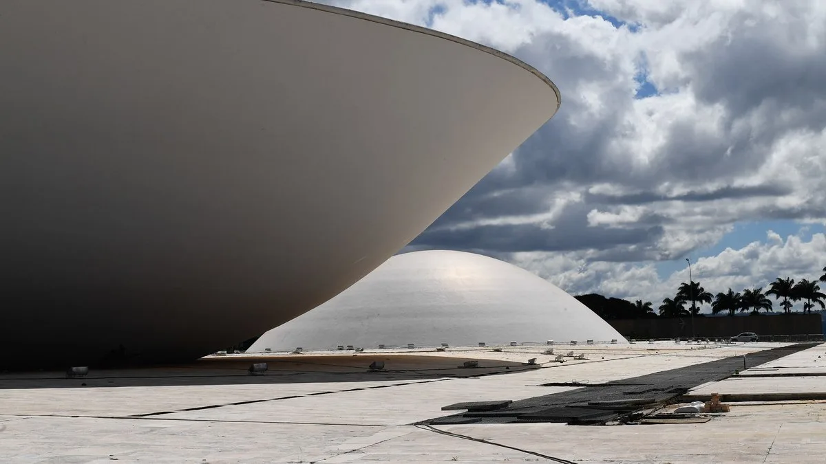 Deputados evangélicos em plenário da Câmara, com Bíblias e gestos de oração, durante votação em Brasília.