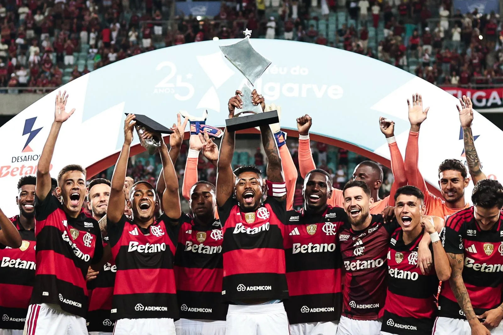 Jogador Samuel Lino comemorando gol com a camisa do Flamengo, no Estádio Algarve, em Portugal, com torcida rubro-negra ao fun